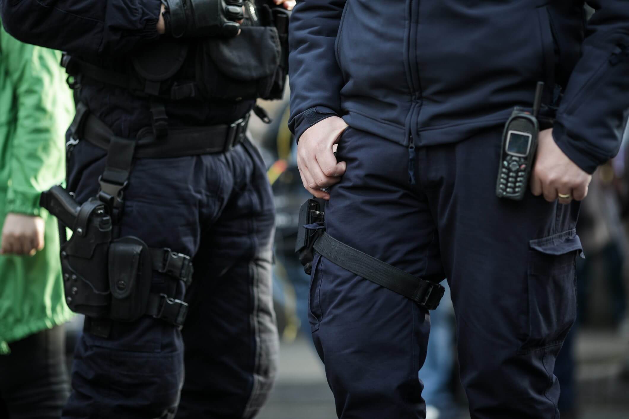 Close-up of police officers in tactical gear standing outdoors.